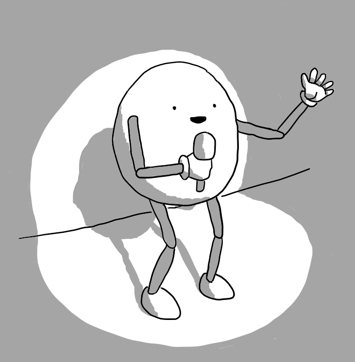 An ovoid robot with jointed arms and legs, standing by a wall with a spotlight shining down directly on it. The robot has a microphone in one hand that it's happily talking into while it gestures with the other.