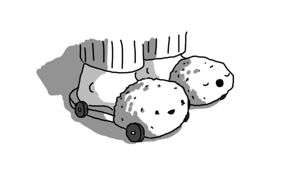 Two robots in the form of fluffy slippers on a person's feet. They have little faces on the front and four wheels on their undersides. One Slipperbot is smiling and the other is yawning.