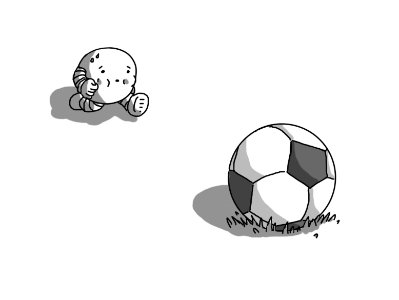 A little round robot with banded arms and legs, huffing and puffing as it runs towards a football nestling in the grass in the foreground.