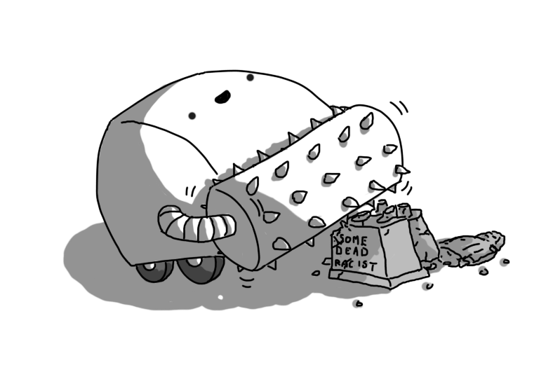 A large, wheeled robot with a roughly semi-cylindrical shape, sporting a spiked roller on its front. It's cheerfully driving over a toppled statue, angled onto its crumbling plinth, which reads 'SOME DEAD RACIST'.